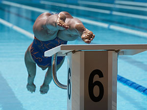 Female Swimmer Jumps Off Starting Block And Start Swims In Pool