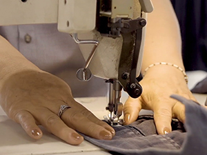 hands fixing uniform with sewing machine