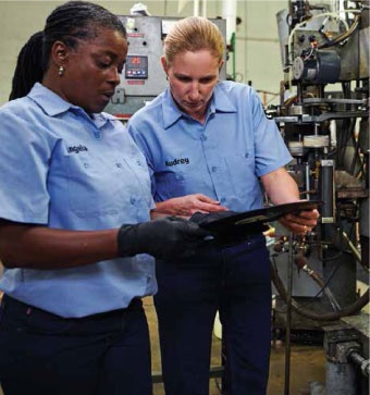 two women in manufacturing uniforms